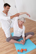 Sport coach training senior woman with stretching exercises Sport coach training senior woman with stretching exercises