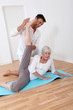 Sport coach training senior woman with stretching exercises Sport coach training senior woman with stretching exercises