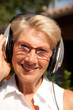 femme sénior souriante écoutant de la musique