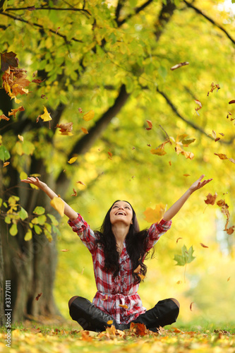 Photo: woman drop leaves in autumn park woman drop leaves in autumn park