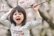 桜の下で声を出している女の子