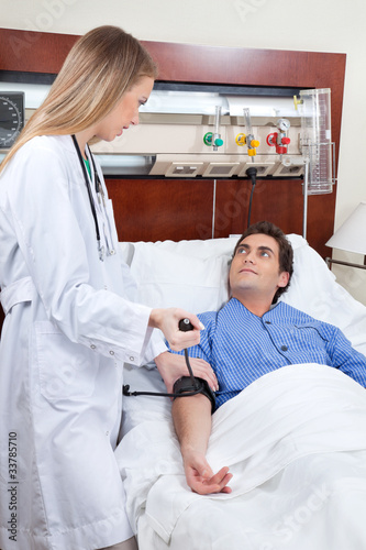 Photo: Doctor checking the blood pressure of patient Doctor checking the blood pressure of patient