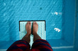 feet on diving board over pool