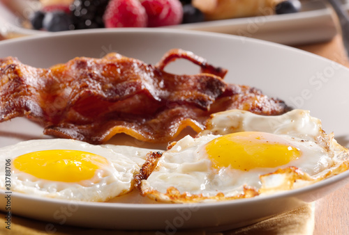 Photo: sunny side up eggs with fried bacon. sunny side up eggs with fried bacon.