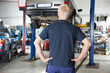 Rear view mechanic looking at car