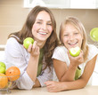 Happy Mother with Daughter eating Healthy food. Diet