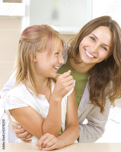 Photo: Mother with teenage Daughter having fun. Kitchen. Happy family Mother with teenage Daughter having fun. Kitchen. Happy family