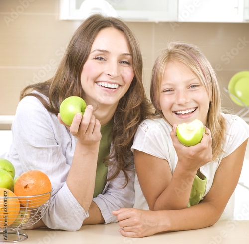 Photo: Happy Mother with Daughter eating Healthy food. Diet Happy Mother with Daughter eating Healthy food. Diet