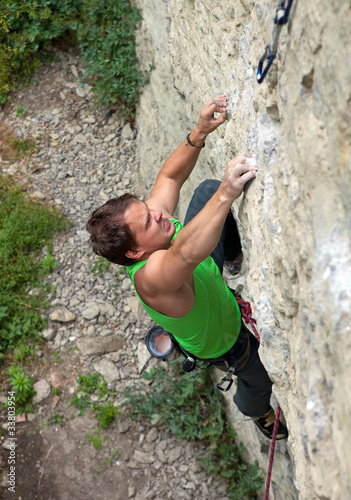Photo: Rock climber struggling to reach next handhold Rock climber struggling to reach next handhold