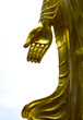 The golden hand of Buddha standing in a temple of Thailand.