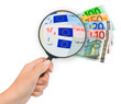 Hand with magnifying glass and money