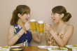 飲み会中ビールで乾杯をする女性2人