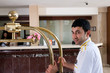 Photo: Bellboy and receptionists at the background. Bellboy and receptionists at the background.