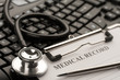 Doctor's stethoscope and medical record on computer keyboard