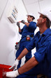 Electricians installing circuit breaker