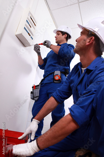 Photo: Electricians installing circuit breaker Electricians installing circuit breaker