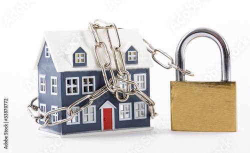 Foto: House secured with chain and padlock on a white background House secured with chain and padlock on a white background