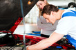 Foto: Frau spricht mit Automechaniker in Werkstatt Frau spricht mit Automechaniker in Werkstatt