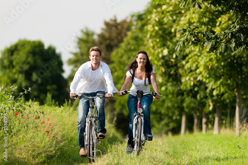 Photo: Man and woman cycling in summer Man and woman cycling in summer