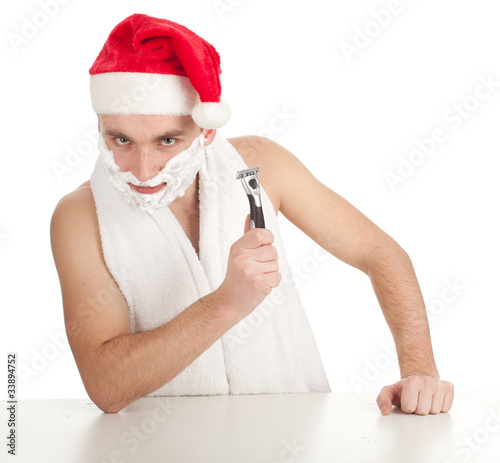 Photo: shaving man with foam and razor in red Christmsa hat shaving man with foam and razor in red Christmsa hat