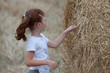 Jeune fille devant botte de foin