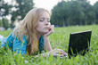 pretty woman with laptop on the green grass