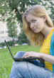 pretty woman with laptop on the green grass