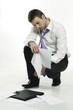 disappointed young businessman picking up files from the floor