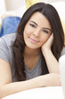 Beautiful Hispanic Woman Laying on Sofa Relaxing & Smiling