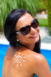 Frau mit Sonnencreme am Schwimmbad