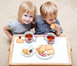 Funny children are eating dessert