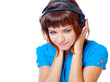 Red-haired teen-girl listen to music in headphones with laptop