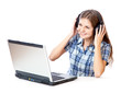 Red-haired teen-girl listen to music in headphones with laptop