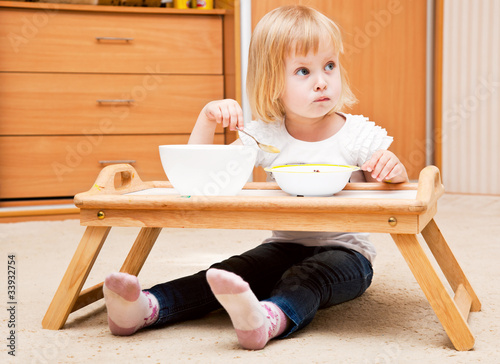 Photo: A small girl is eating A small girl is eating