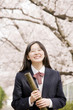 卒業証書の筒を持って笑っている女子中学生