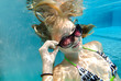 Mädchenportrait mit Sonnenbrille unter Wasser