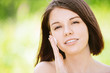 portrait of young attractive woman putting cream on her face
