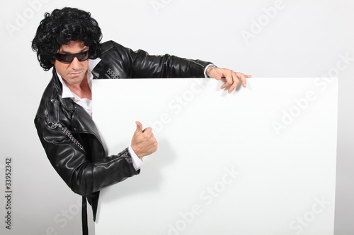 Photo: Man dressed as Elvis holding message board Man dressed as Elvis holding message board