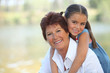 Young girl riding piggy-back on her grandmother's back