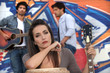 musicians in front of a tagged wall