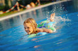 smiling toddler girl swimming in outdoor pool smiling toddler girl swimming in outdoor pool