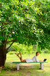 Young woman smiling notebook bench tree park