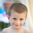 Enfant de 4 ans, blond, avec un crayon derrière l'oreille.