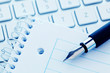 Notizblock und Tastatur eines Computers