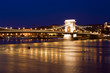 Budapest skyline, reflected on the river bridge at night.