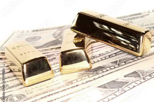 Photo: drei große Goldbarren auf Dollarnoten drei große Goldbarren auf Dollarnoten