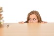 Foto: Junge Frau versteckt sich hinter dem Schreibtisch Junge Frau versteckt sich hinter dem Schreibtisch