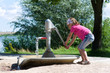 Mädchen an der Wasserpumpe