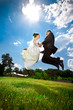newly married couple jumping high holding hands