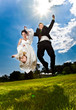 Young newly married couple jumping high holding hands